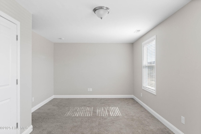 unfurnished room featuring light carpet