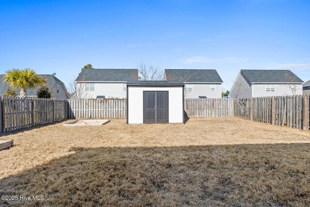 back of property featuring a storage shed and a yard