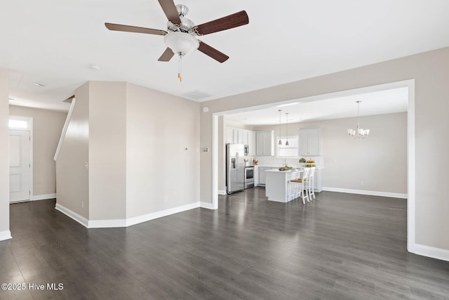 unfurnished living room featuring dark hardwood / wood-style floors and ceiling fan with notable chandelier