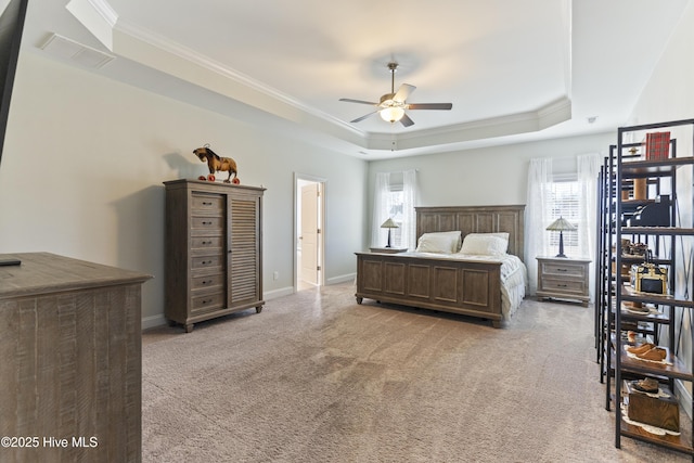 carpeted bedroom with a tray ceiling, ornamental molding, and ceiling fan