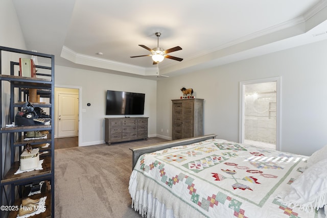 bedroom with connected bathroom, light carpet, ornamental molding, a tray ceiling, and ceiling fan