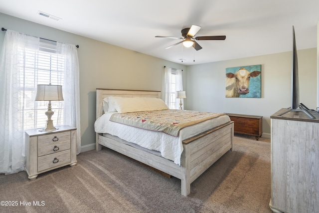 bedroom featuring multiple windows, dark colored carpet, and ceiling fan