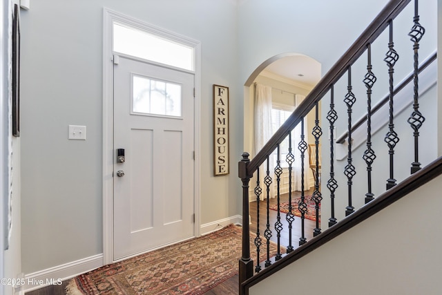 foyer entrance featuring crown molding and hardwood / wood-style floors