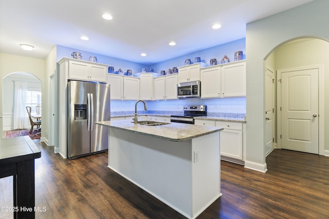 kitchen featuring an island with sink, appliances with stainless steel finishes, sink, and white cabinets