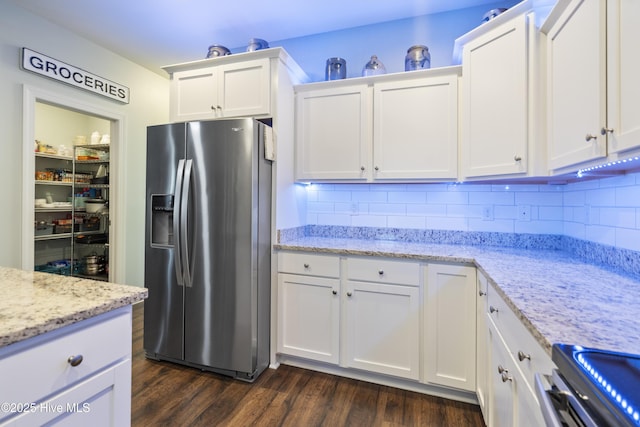 kitchen featuring dark wood-type flooring, white cabinetry, backsplash, stainless steel refrigerator with ice dispenser, and light stone counters