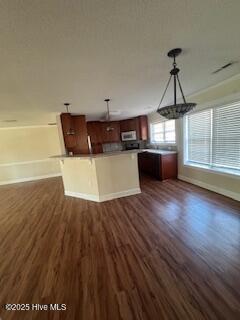 kitchen with open floor plan, hanging light fixtures, dark wood-style flooring, and baseboards