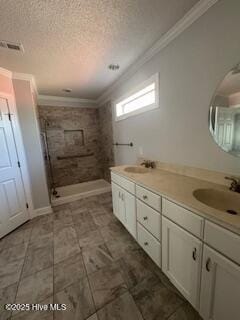 full bathroom featuring visible vents, ornamental molding, a textured ceiling, a shower stall, and a sink