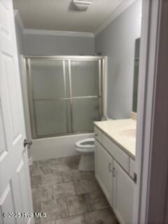 bathroom featuring visible vents, bath / shower combo with glass door, toilet, ornamental molding, and vanity