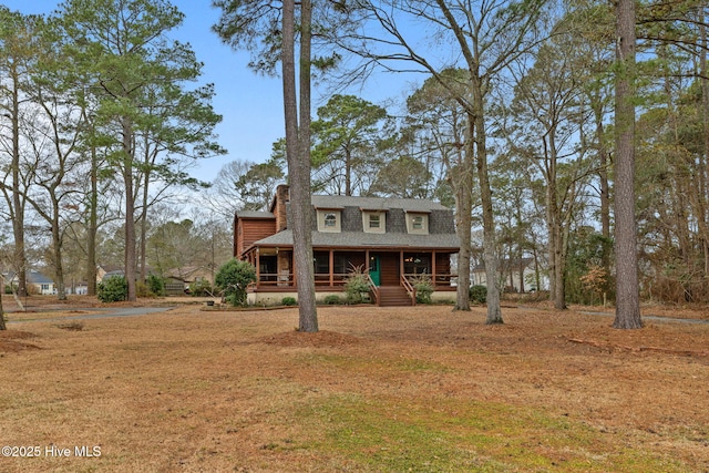 view of front of property with a chimney, a porch, and a shingled roof