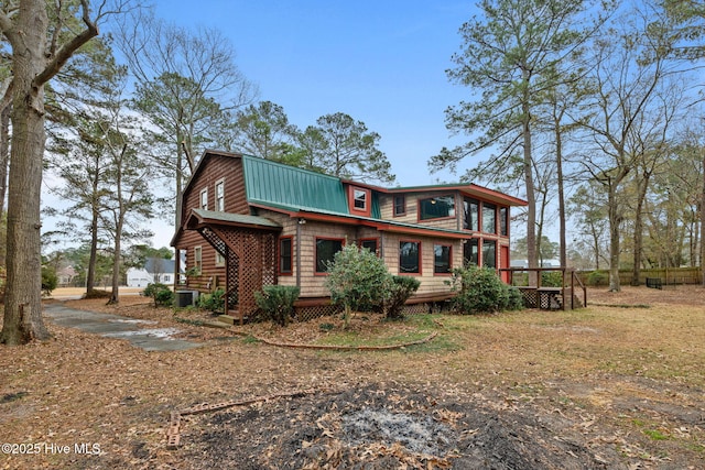 exterior space featuring a gambrel roof, a wooden deck, and metal roof