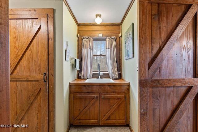 hall featuring crown molding, a barn door, and sink