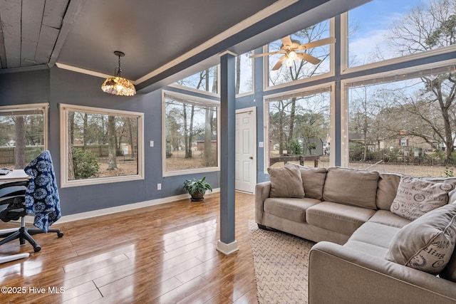 sunroom with ceiling fan with notable chandelier