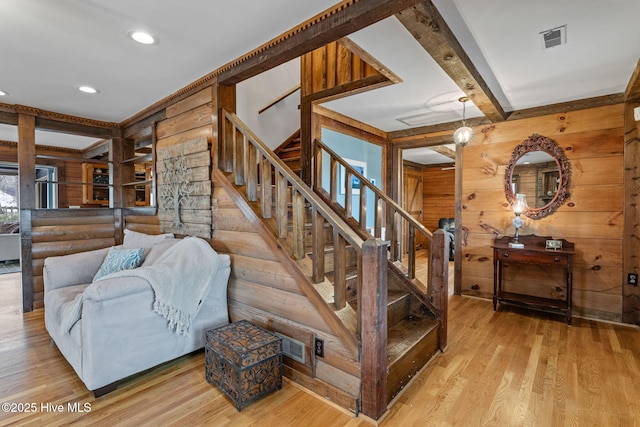 stairs featuring beamed ceiling, hardwood / wood-style floors, and wood walls