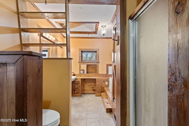 interior space featuring tile patterned flooring, vanity, an enclosed shower, and toilet