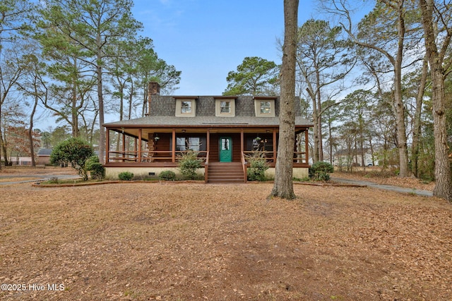 view of front of property featuring a chimney, a shingled roof, and covered porch