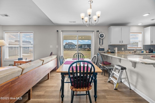 dining room featuring an inviting chandelier and light hardwood / wood-style flooring