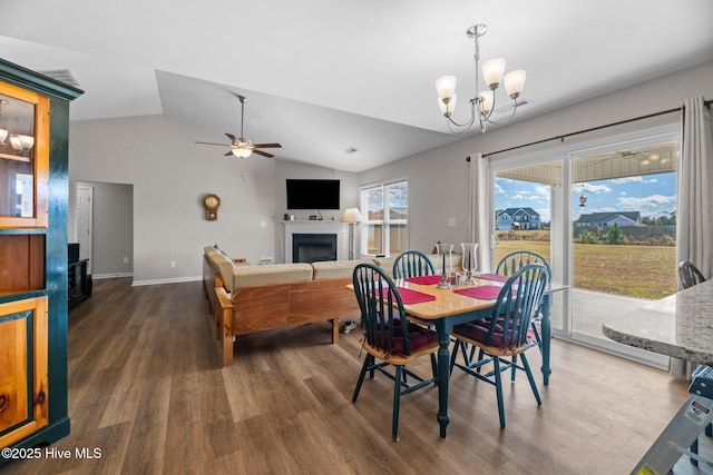 dining space featuring vaulted ceiling, dark wood-type flooring, and ceiling fan with notable chandelier