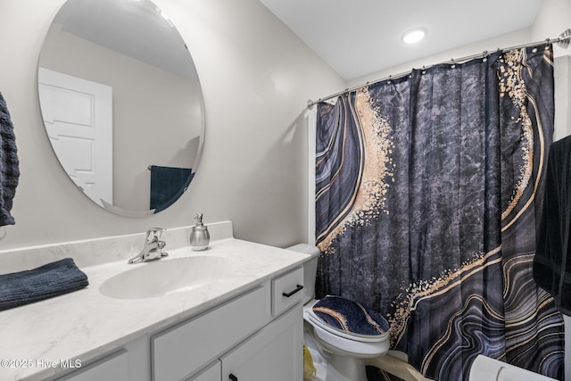 bathroom with toilet, vanity, and curtained shower