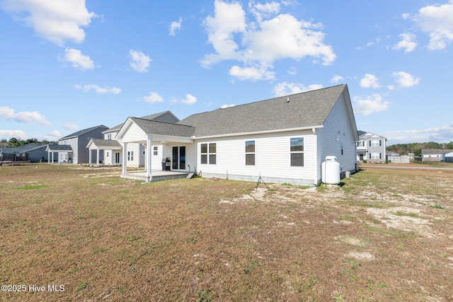 back of house featuring a patio area and a yard