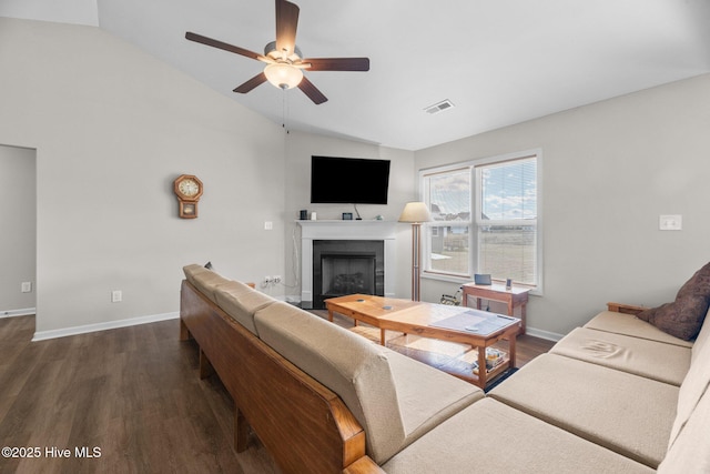 living room with ceiling fan, lofted ceiling, dark hardwood / wood-style floors, and a tile fireplace