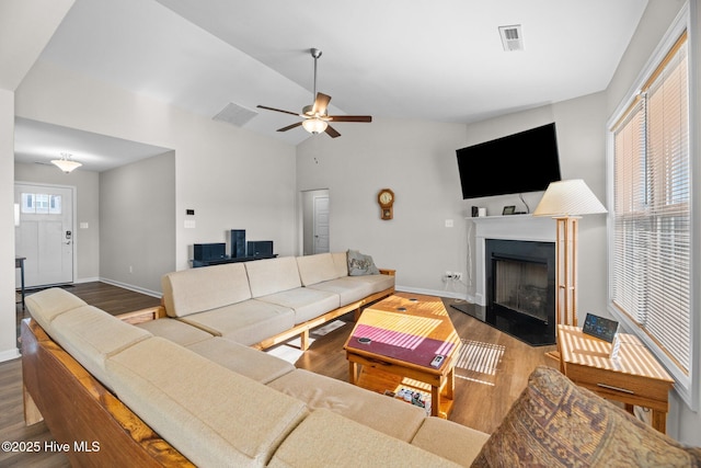 living room with ceiling fan, dark wood-type flooring, and vaulted ceiling