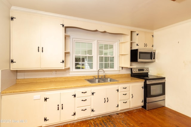 kitchen featuring dark wood-type flooring, sink, ornamental molding, white cabinetry, and stainless steel appliances