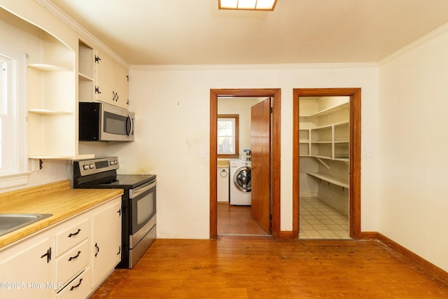 kitchen with washing machine and dryer, light wood-type flooring, ornamental molding, appliances with stainless steel finishes, and white cabinetry