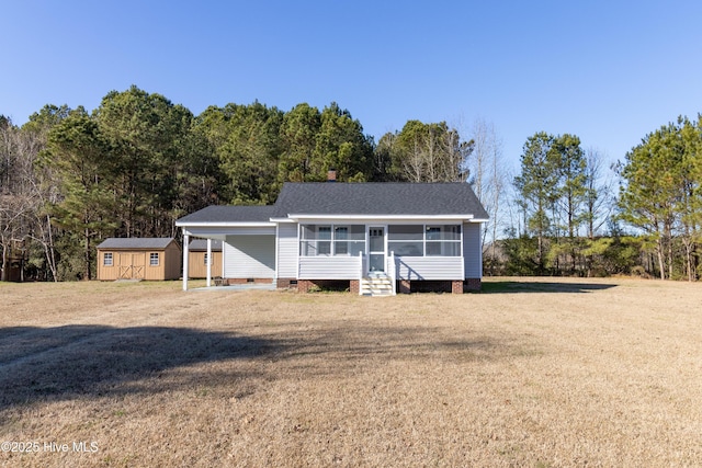 view of front of house featuring a storage shed and a front lawn