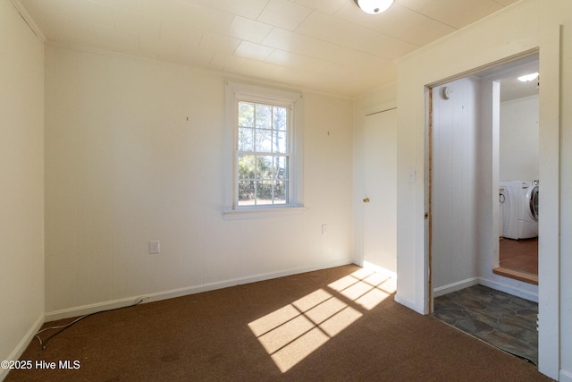 unfurnished bedroom featuring dark carpet and independent washer and dryer