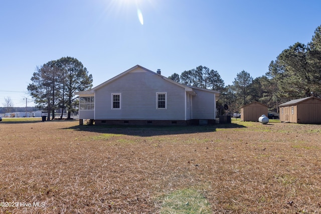 view of side of property with a shed and a yard