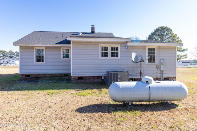 back of property with central AC and a lawn