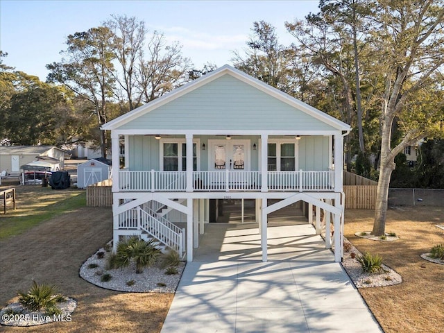 view of front of house featuring a porch, a carport, and a storage shed