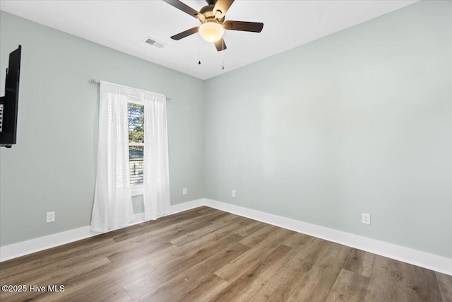 empty room with ceiling fan and hardwood / wood-style flooring