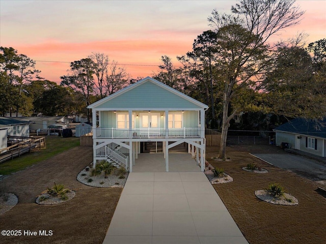 raised beach house with a porch and a carport