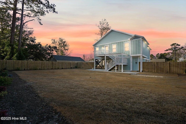 back house at dusk featuring a yard