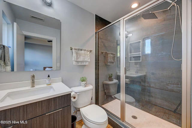 bathroom featuring toilet, vanity, and an enclosed shower