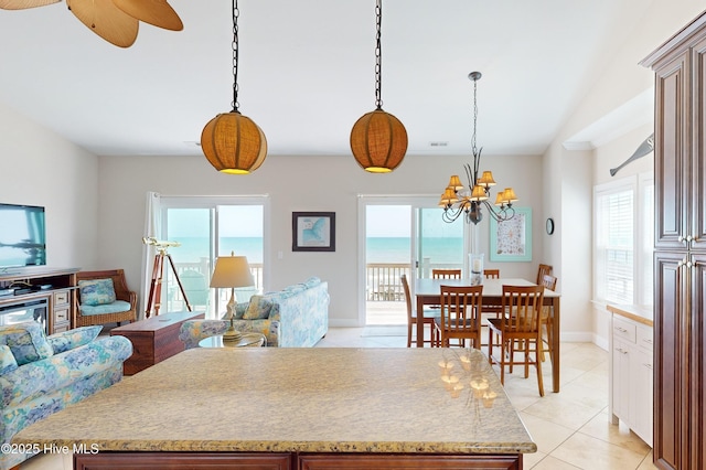 kitchen featuring a wealth of natural light, a water view, and hanging light fixtures