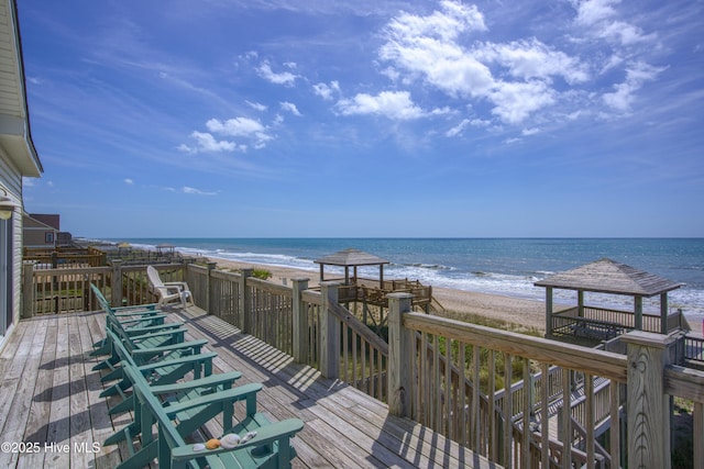 deck featuring a view of the beach, a gazebo, and a water view