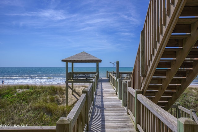 view of community featuring a water view and a beach view