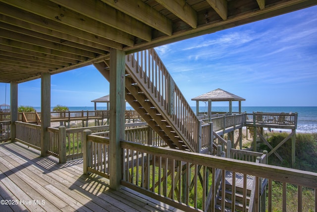 wooden terrace with a view of the beach and a water view