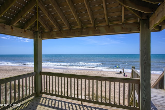 wooden terrace with a water view and a beach view