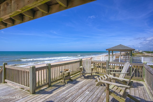 deck featuring a view of the beach, a gazebo, and a water view