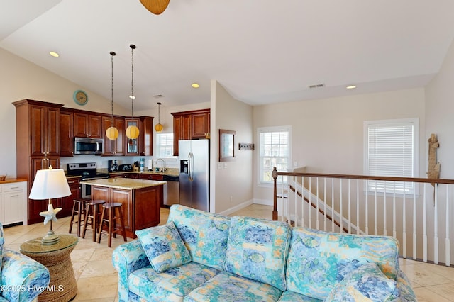 living room featuring light tile patterned floors, lofted ceiling, and sink