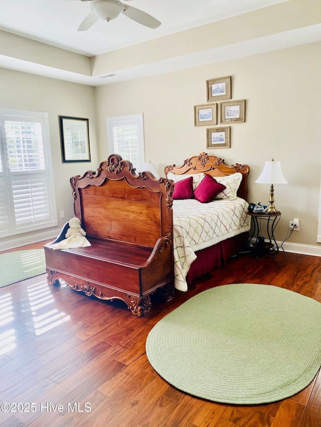 bedroom with multiple windows, hardwood / wood-style floors, and ceiling fan