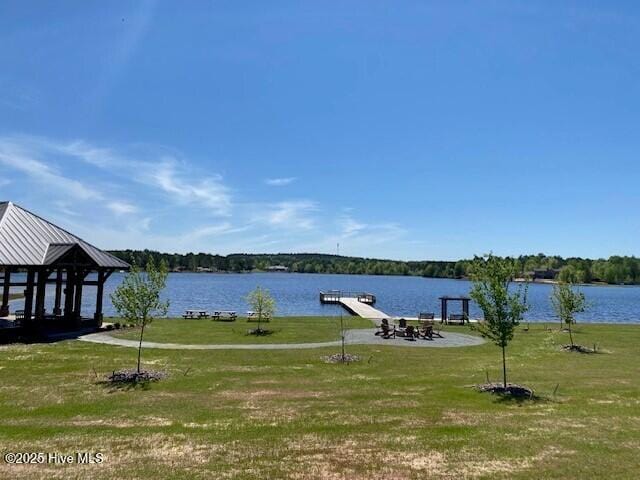 view of dock featuring a water view and a yard