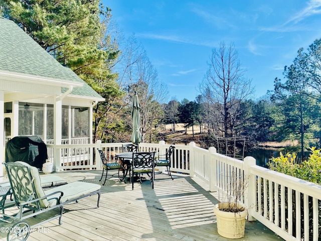 wooden terrace featuring a grill and a sunroom