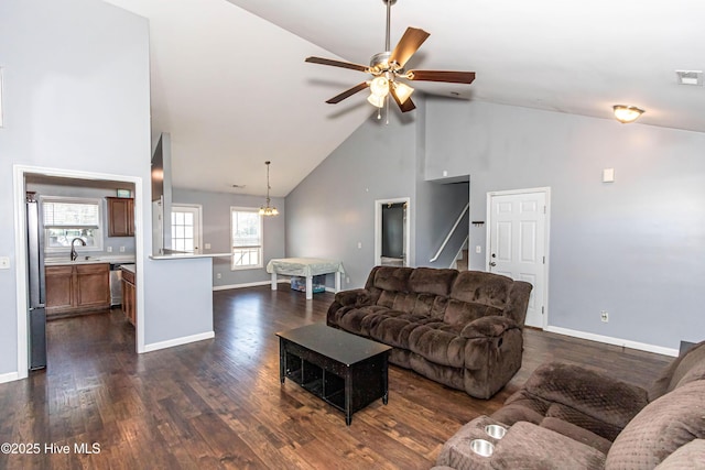 living room featuring high vaulted ceiling, sink, ceiling fan with notable chandelier, and dark hardwood / wood-style flooring