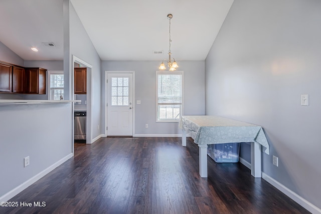 foyer featuring lofted ceiling, dark wood-type flooring, and a chandelier