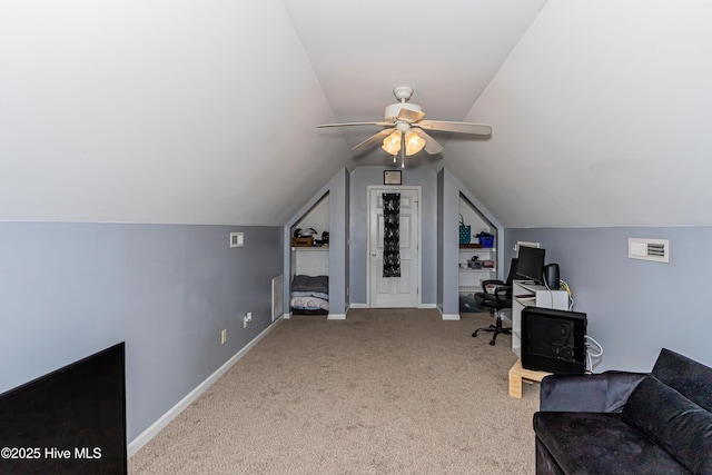 unfurnished office featuring lofted ceiling, light colored carpet, and ceiling fan