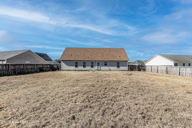 rear view of house featuring a lawn